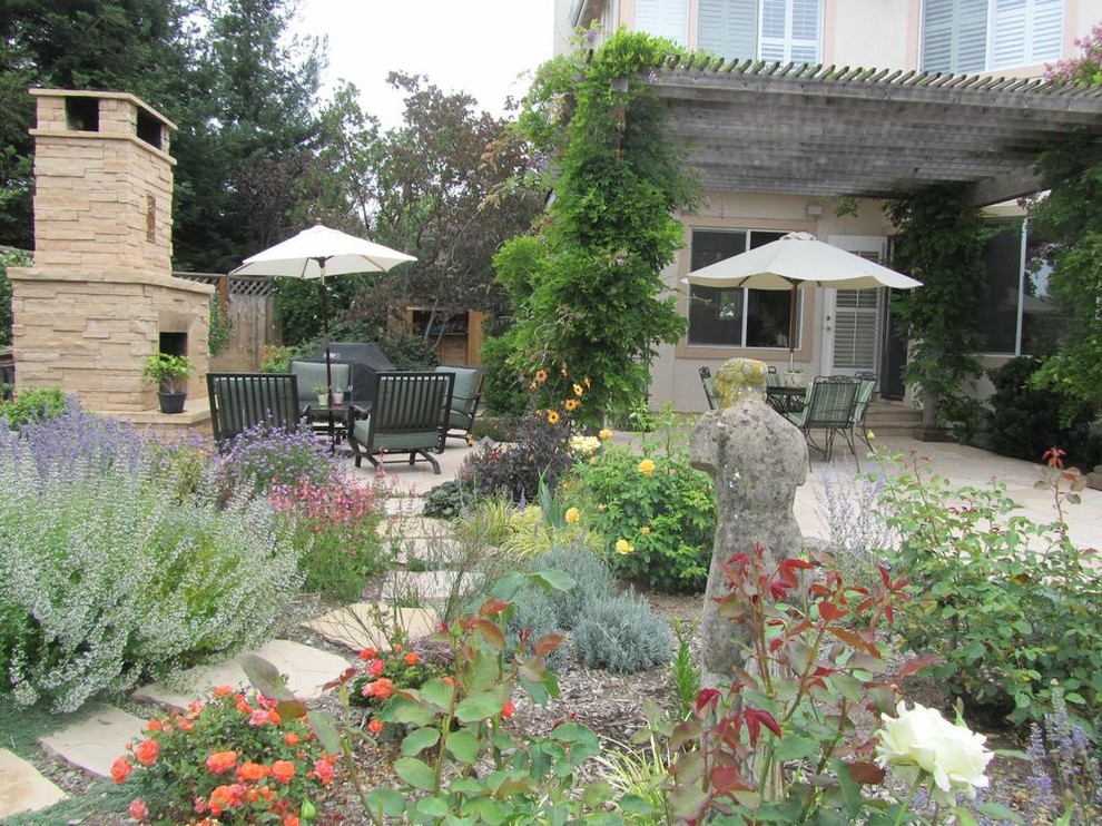 Photo of an eclectic garden in San Francisco with a fire feature and natural stone pavers.