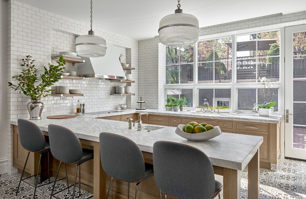 Photo of a transitional u-shaped eat-in kitchen in Chicago with an undermount sink, recessed-panel cabinets, light wood cabinets, quartzite benchtops, white splashback, porcelain floors, a peninsula, multi-coloured floor, white benchtop and subway tile splashback.