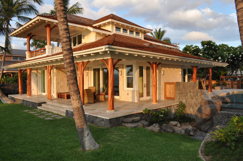 Inspiration for a mid-sized tropical two-storey exterior in Hawaii with stone veneer.