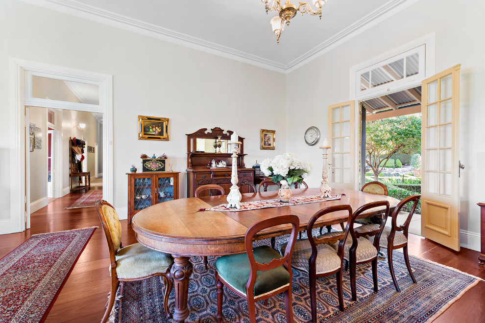 Traditional separate dining room in Sydney with white walls, medium hardwood floors, no fireplace and brown floor.
