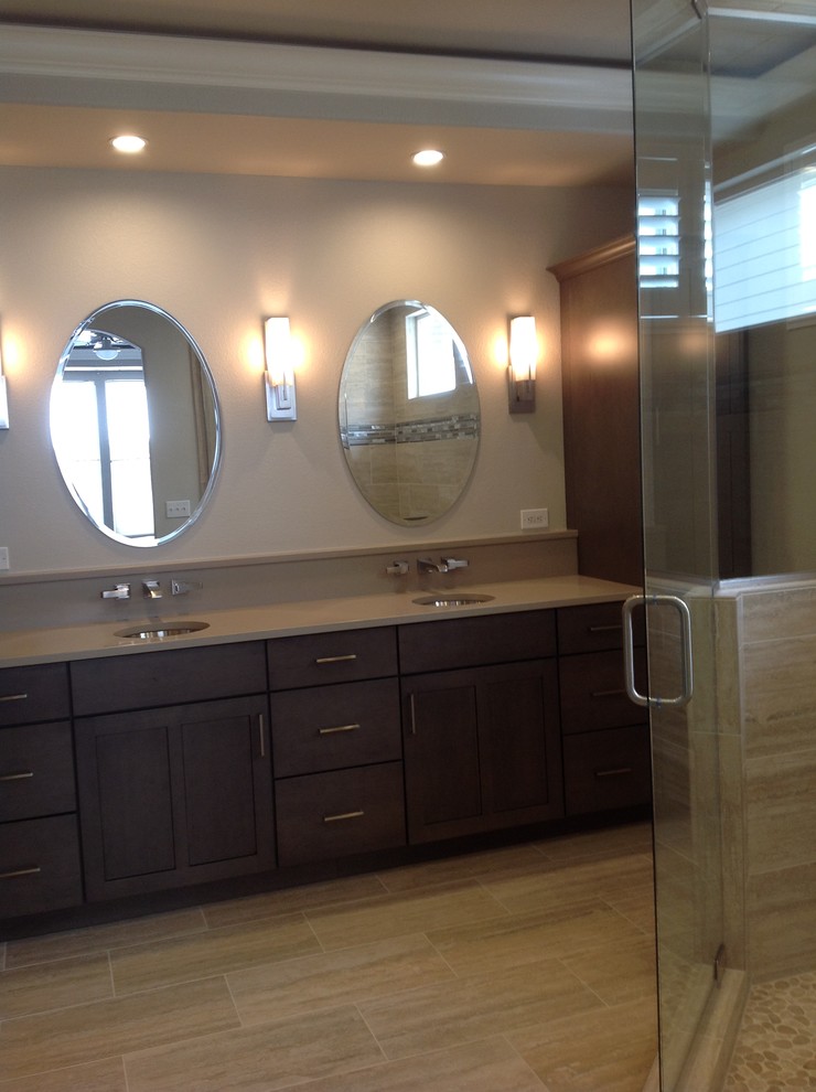 Example of a mid-sized transitional 3/4 porcelain tile and double-sink corner shower design in Denver with shaker cabinets, dark wood cabinets, beige walls, an undermount sink, solid surface countertops, gray countertops and a built-in vanity