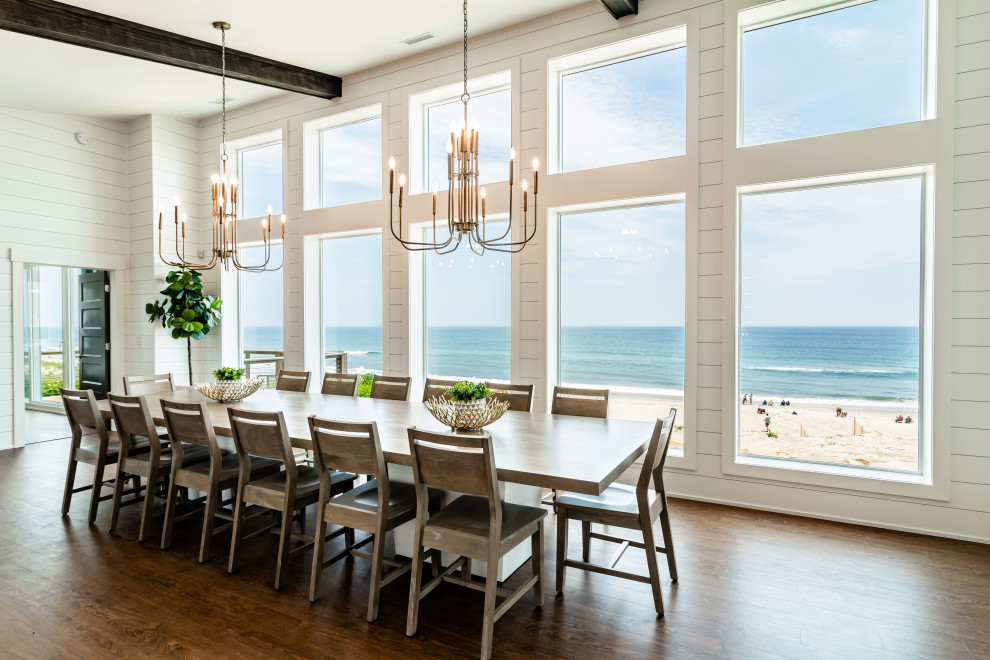 Large beach style open plan dining in Other with white walls, medium hardwood floors, no fireplace and brown floor.