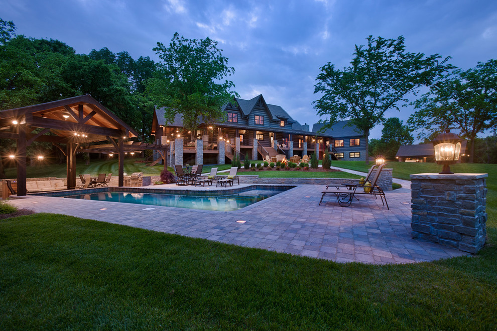 This is an example of a large country backyard l-shaped lap pool in Nashville with concrete pavers.