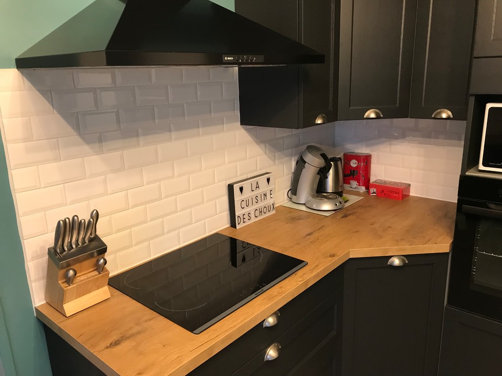 This is an example of a mid-sized midcentury l-shaped separate kitchen in Lille with a farmhouse sink, glass-front cabinets, dark wood cabinets, laminate benchtops, white splashback, subway tile splashback, white appliances, cement tiles, no island and grey floor.