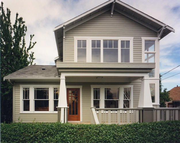 This is an example of a large arts and crafts three-storey beige house exterior in Seattle.