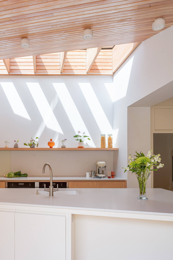 Esempio di una grande cucina scandinava con ante lisce, ante in legno chiaro, top in superficie solida, pavimento in mattoni e top grigio