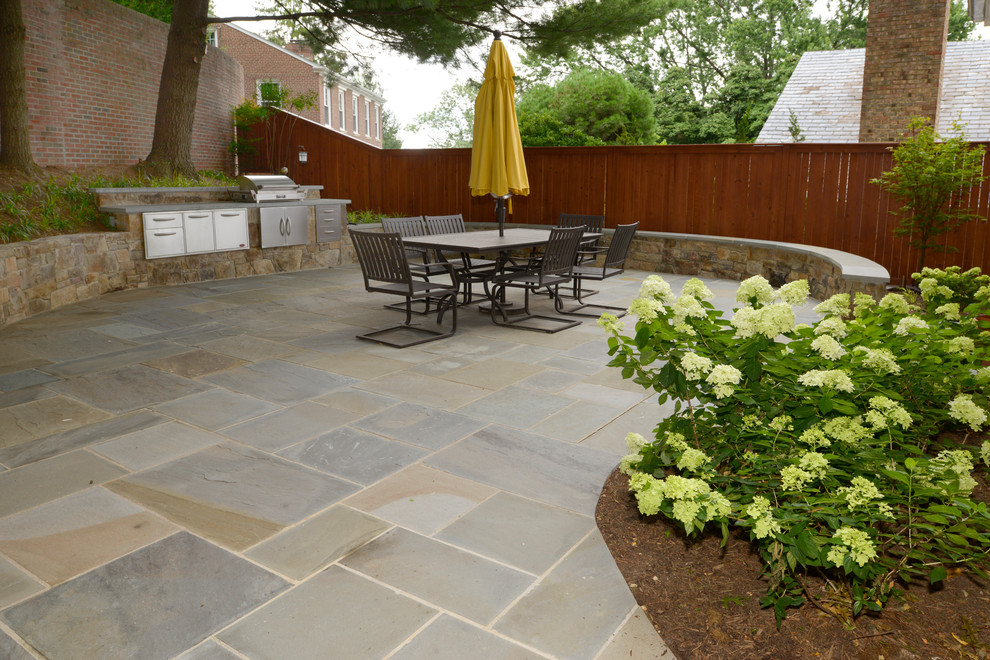 Design ideas for a large transitional backyard patio in DC Metro with natural stone pavers.