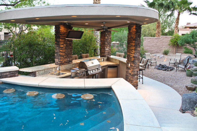 This is an example of a large transitional backyard patio in Las Vegas with an outdoor kitchen, concrete slab and a gazebo/cabana.