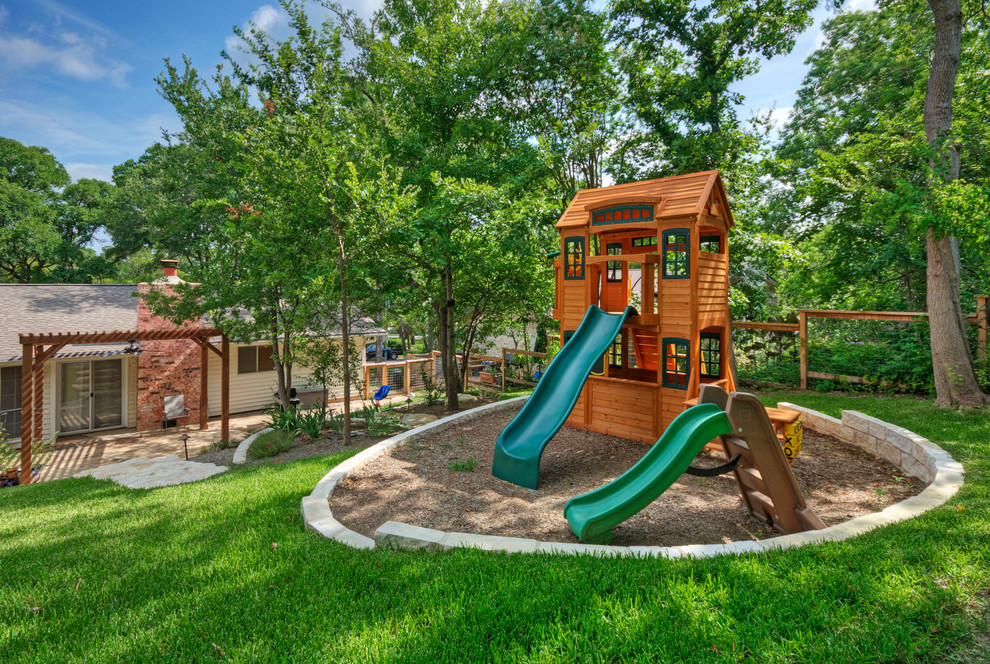This is an example of a traditional garden in Austin with with outdoor playset.