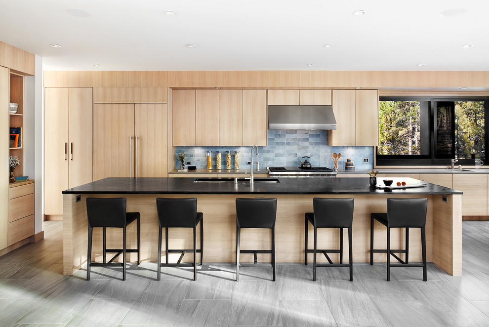 This is an example of a contemporary galley kitchen in San Francisco with an undermount sink, flat-panel cabinets, light wood cabinets, grey splashback and with island.