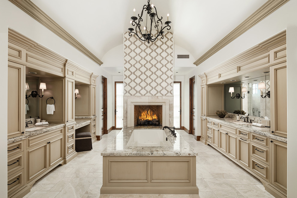 This is an example of an expansive mediterranean master bathroom in Phoenix with recessed-panel cabinets, beige cabinets, an undermount tub, white walls, an undermount sink, marble floors, granite benchtops and beige floor.
