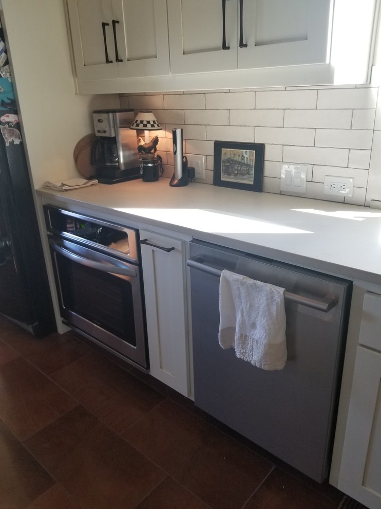 Inspiration for a transitional kitchen remodel in Dallas with shaker cabinets, white backsplash, mirror backsplash, stainless steel appliances and white countertops