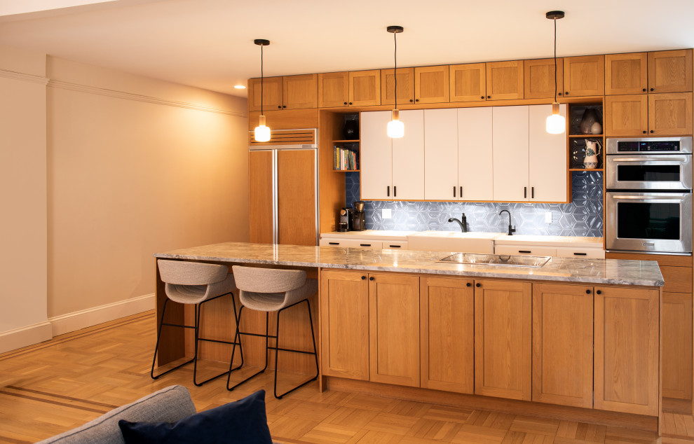 Photo of a mid-sized midcentury kitchen in Los Angeles with an undermount sink, shaker cabinets, light wood cabinets, marble benchtops, black splashback, ceramic splashback, panelled appliances, light hardwood floors, with island, beige floor and blue benchtop.