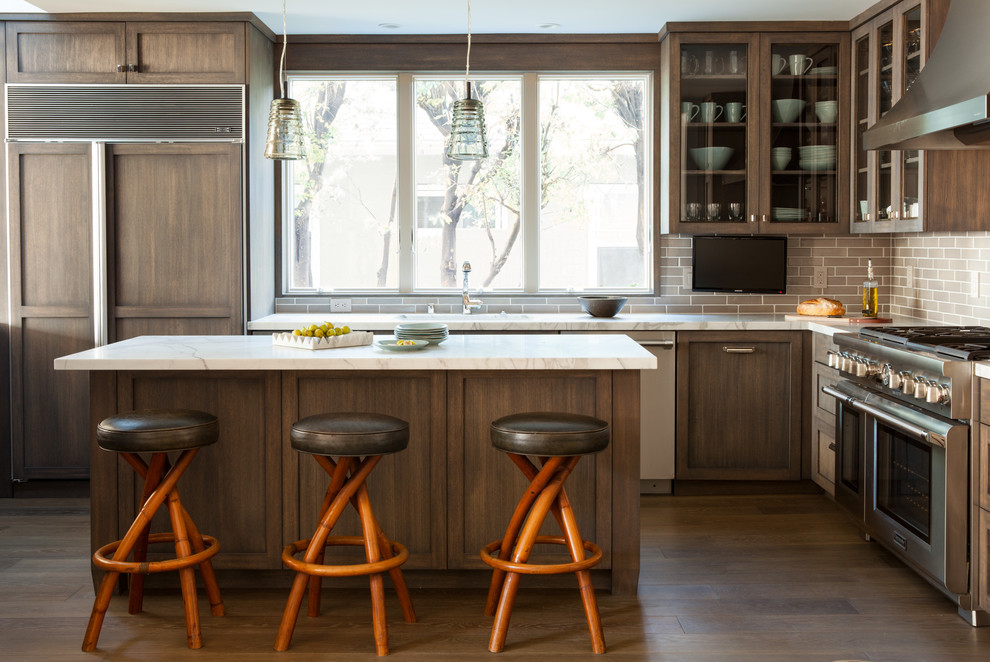 Mid-sized transitional l-shaped separate kitchen in San Francisco with an undermount sink, shaker cabinets, dark wood cabinets, grey splashback, subway tile splashback, stainless steel appliances, dark hardwood floors, with island and marble benchtops.