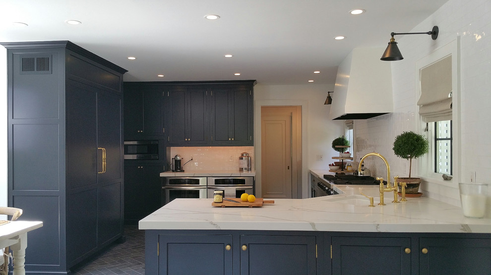 Mid-sized transitional u-shaped eat-in kitchen in New York with an undermount sink, recessed-panel cabinets, black cabinets, quartzite benchtops, white splashback, subway tile splashback, stainless steel appliances, ceramic floors, a peninsula, black floor and white benchtop.