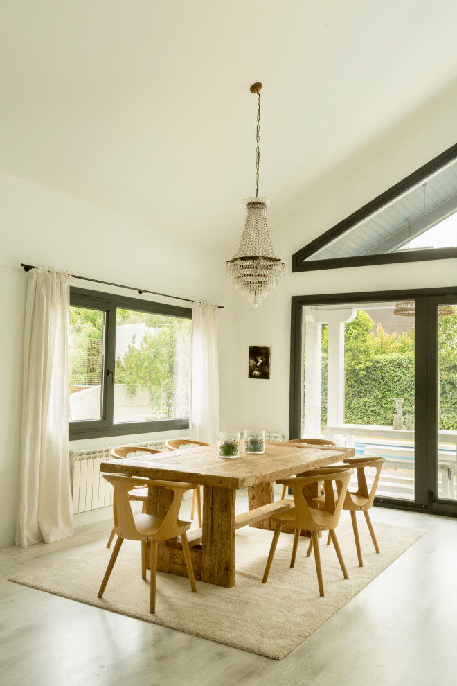 Ejemplo de comedor abovedado escandinavo de tamaño medio con paredes blancas, suelo de madera clara, todas las chimeneas y suelo blanco