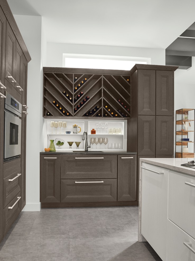 Photo of a large contemporary l-shaped wet bar in Detroit with an undermount sink, recessed-panel cabinets, dark wood cabinets, quartz benchtops, concrete floors, grey floor and grey benchtop.