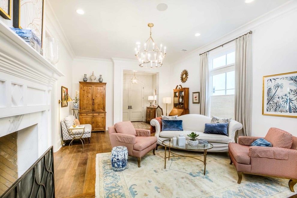 Large transitional formal living room in New Orleans with white walls, medium hardwood floors, a two-sided fireplace, a stone fireplace surround, no tv and brown floor.