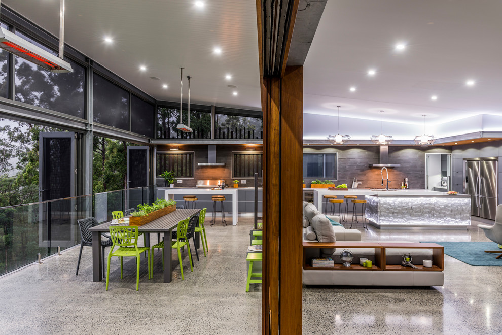 This is an example of an expansive contemporary dining room in Brisbane with concrete floors and white walls.