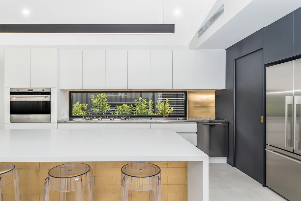 Inspiration for a contemporary kitchen in Perth with an integrated sink, flat-panel cabinets, white cabinets, stainless steel benchtops, window splashback, stainless steel appliances, concrete floors, with island and grey floor.