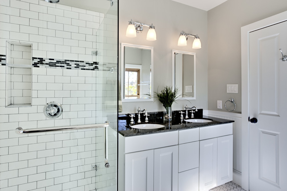Traditional bathroom in New York with an undermount sink, recessed-panel cabinets, white cabinets, an alcove shower, white tile and subway tile.