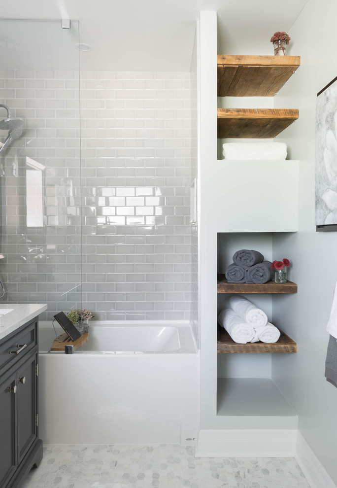 Inspiration for a mid-sized contemporary master bathroom in Toronto with an undermount sink, recessed-panel cabinets, grey cabinets, an alcove tub, a shower/bathtub combo, gray tile, subway tile, grey walls, marble floors and grey floor.