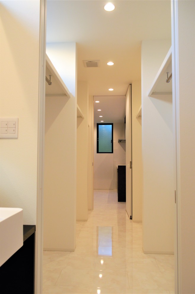 На фото: гардеробная комната унисекс в стиле модернизм с фасадами с декоративным кантом, полом из фанеры и белым полом с