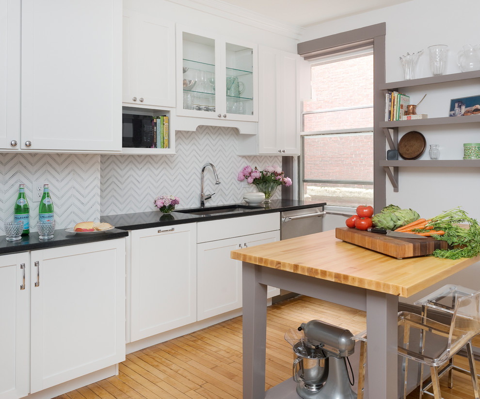Inspiration for a transitional light wood floor kitchen remodel in Boston with shaker cabinets, an island, an integrated sink, white cabinets, granite countertops and paneled appliances