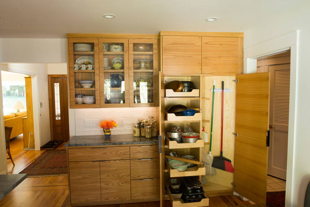 Example of a mid-sized transitional u-shaped medium tone wood floor eat-in kitchen design with an undermount sink, flat-panel cabinets, medium tone wood cabinets, quartzite countertops, white backsplash, ceramic backsplash, stainless steel appliances and an island
