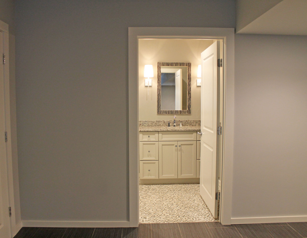 Diseño de sótano con puerta tradicional renovado de tamaño medio con bar en casa, paredes grises, suelo de baldosas de cerámica y suelo negro