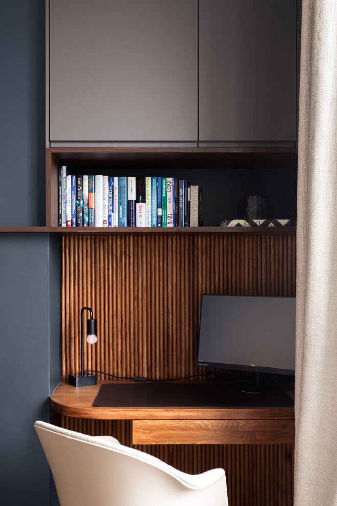 Foto de despacho minimalista de tamaño medio con paredes negras, suelo de madera en tonos medios, todas las chimeneas, marco de chimenea de piedra, escritorio empotrado, madera y madera