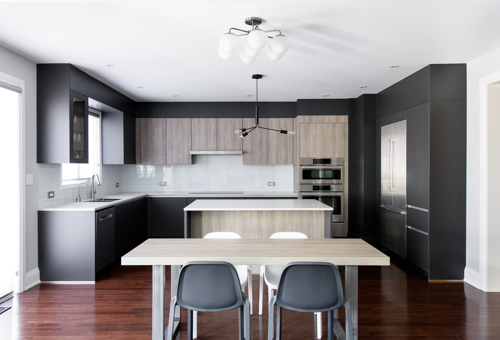 Inspiration for a mid-sized modern l-shaped eat-in kitchen in Toronto with an undermount sink, flat-panel cabinets, white splashback, stainless steel appliances, with island, brown floor, white benchtop, glass sheet splashback and dark hardwood floors.