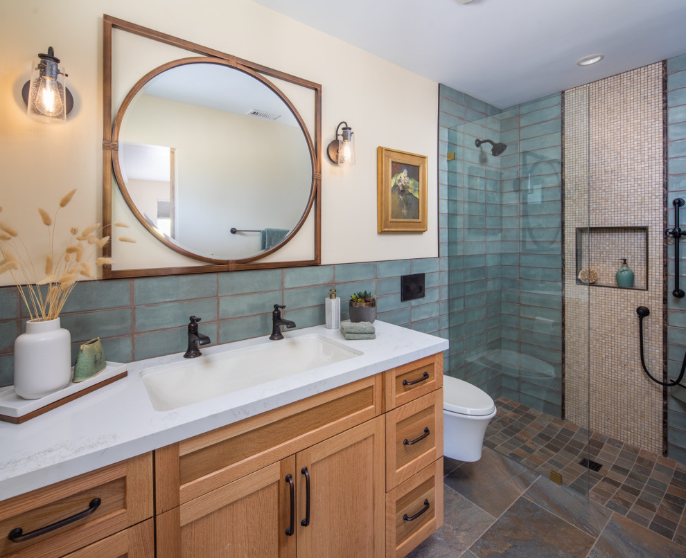 Photo of a mid-sized contemporary bathroom in San Diego with shaker cabinets, light wood cabinets, a curbless shower, a bidet, blue tile, porcelain tile, beige walls, travertine floors, an undermount sink, engineered quartz benchtops, multi-coloured floor, an open shower, white benchtops, a shower seat, a double vanity and a built-in vanity.