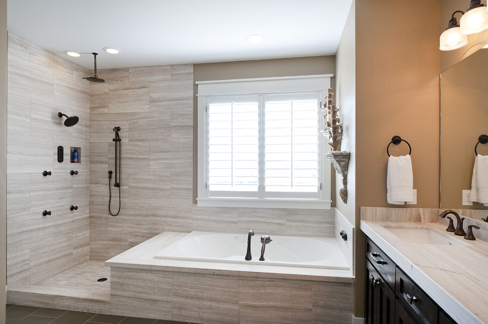 Inspiration for a large arts and crafts master bathroom in Salt Lake City with an undermount sink, recessed-panel cabinets, dark wood cabinets, a corner shower, a one-piece toilet, beige walls, beige tile, ceramic tile and a drop-in tub.