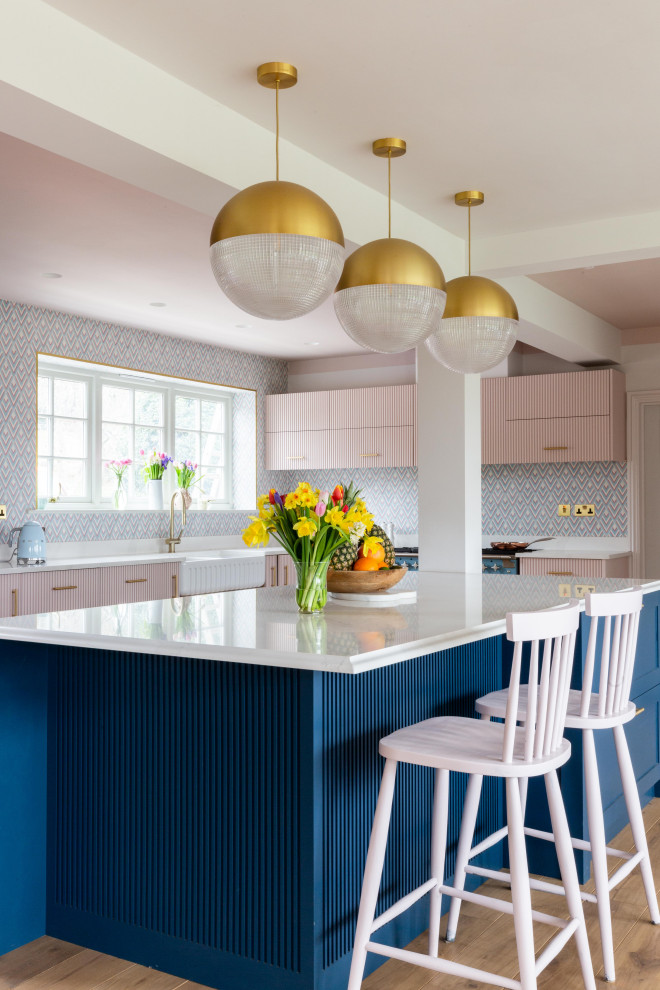 Design ideas for a contemporary u-shaped eat-in kitchen in Hampshire with a farmhouse sink, pink cabinets, with island, recessed-panel cabinets, quartz benchtops and coloured appliances.