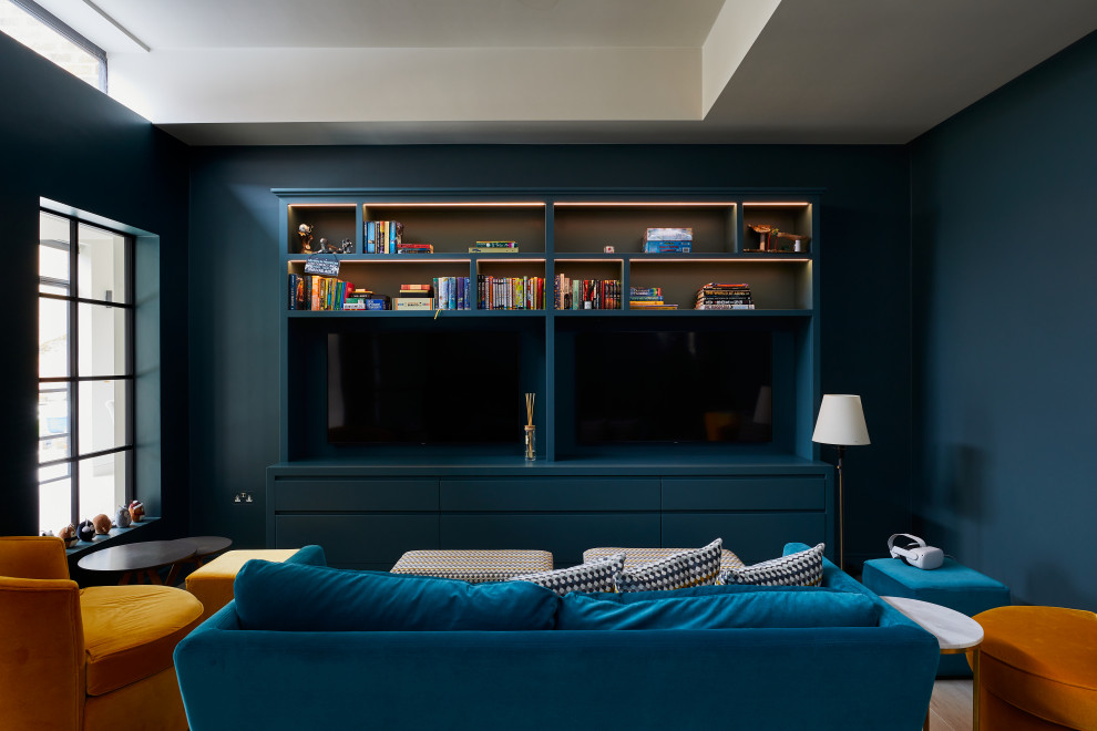 Photo of a medium sized living room in Surrey with blue walls, light hardwood flooring, a standard fireplace and a plastered fireplace surround.