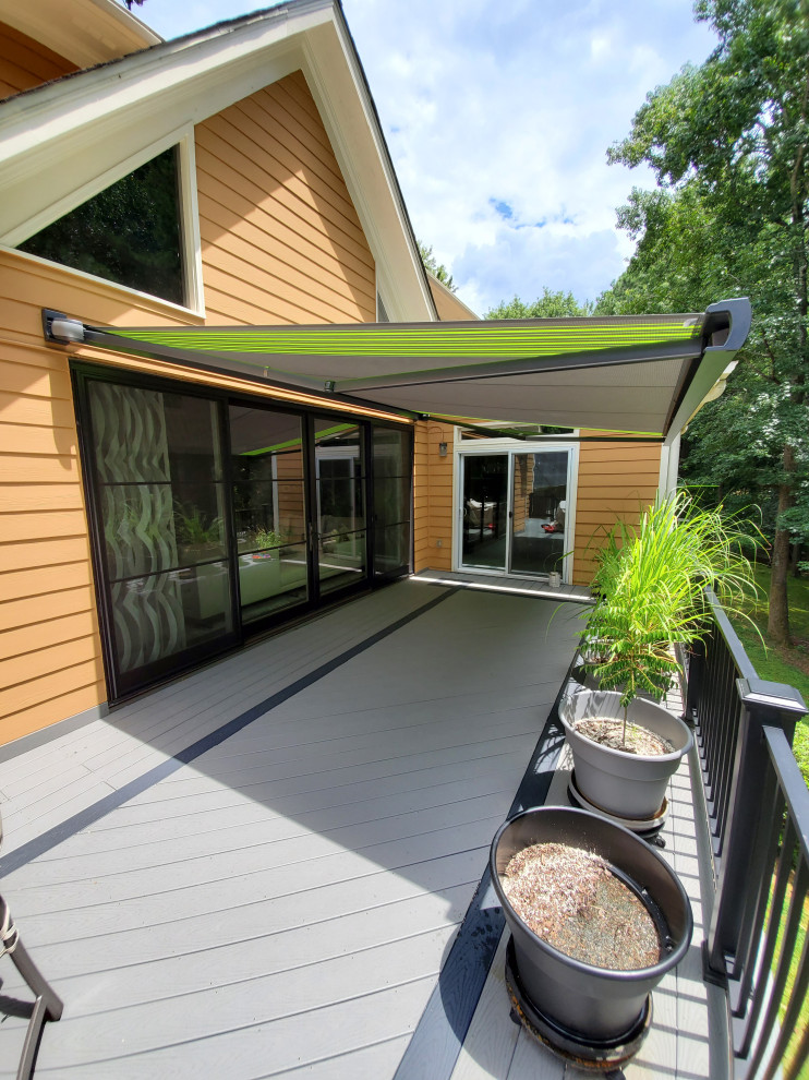 Inspiration for a mid-sized modern backyard and first floor deck in Atlanta with an awning.