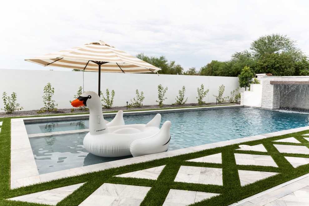 Пример оригинального дизайна: большой естественный, прямоугольный бассейн на заднем дворе в морском стиле с водной горкой и покрытием из каменной брусчатки