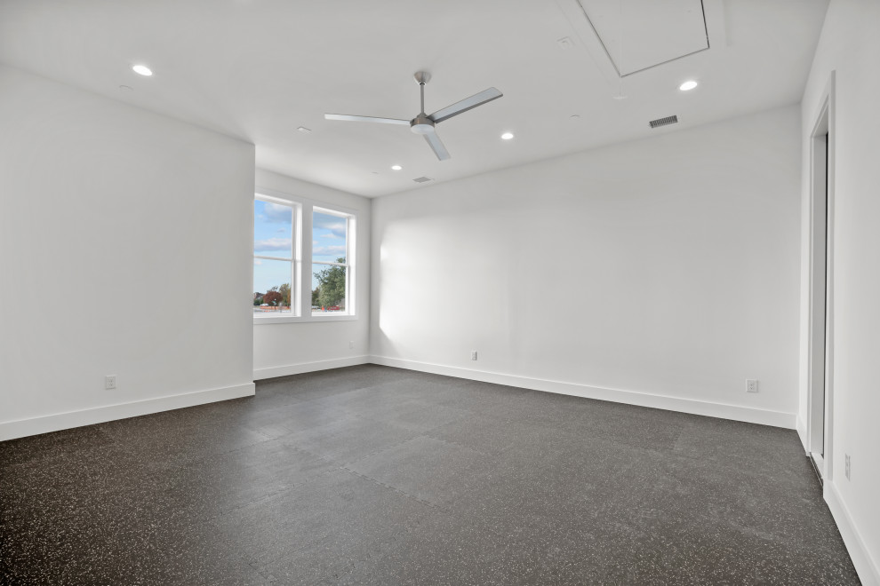This is an example of a mid-sized modern multipurpose gym in Dallas with white walls, cork floors and black floor.