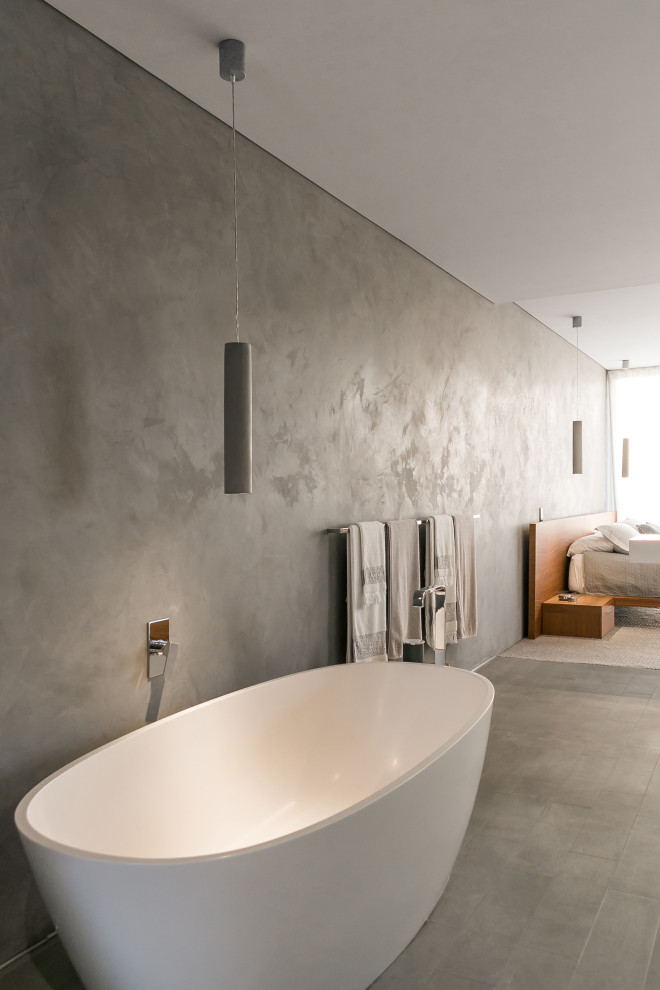 Photo of an industrial master bathroom in Perth with a freestanding tub, an open shower, a one-piece toilet, white tile, marble, grey walls, an integrated sink, engineered quartz benchtops, grey floor, an open shower, white benchtops, a niche, a single vanity and a floating vanity.