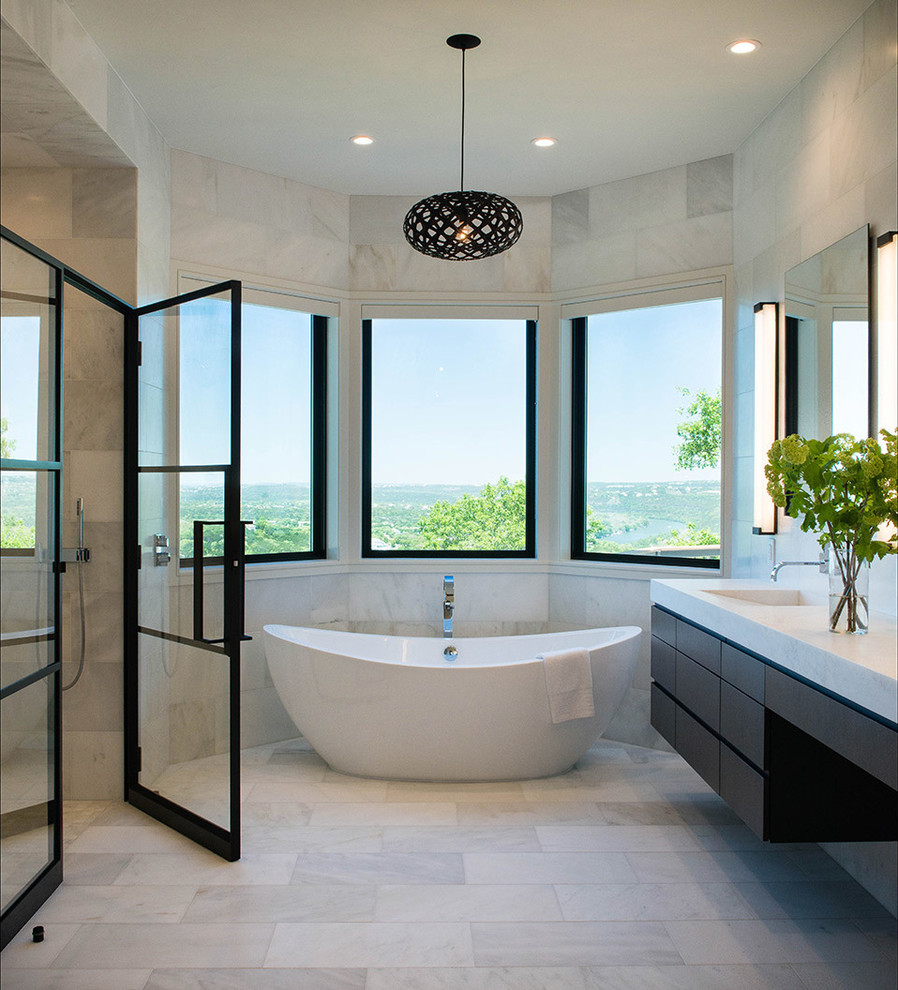 Photo of a contemporary master bathroom in Austin with flat-panel cabinets, dark wood cabinets, a freestanding tub, an integrated sink and a hinged shower door.