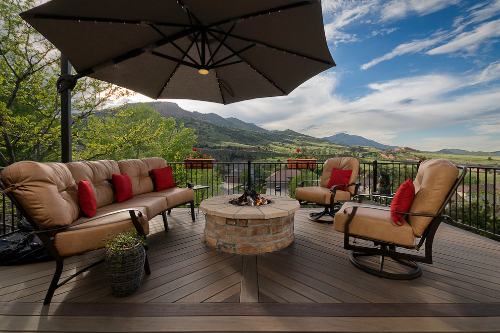 Inspiration for a large traditional backyard deck in Denver with a fire feature, an awning and metal railing.