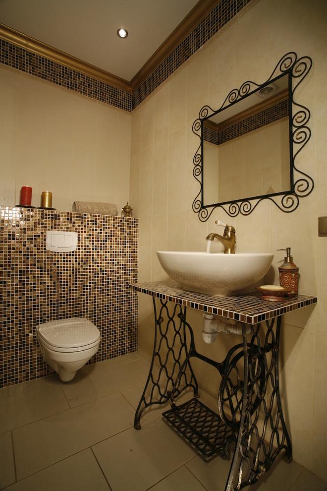 Design ideas for a mediterranean powder room in Moscow with a wall-mount toilet, multi-coloured tile, mosaic tile, beige walls and a vessel sink.