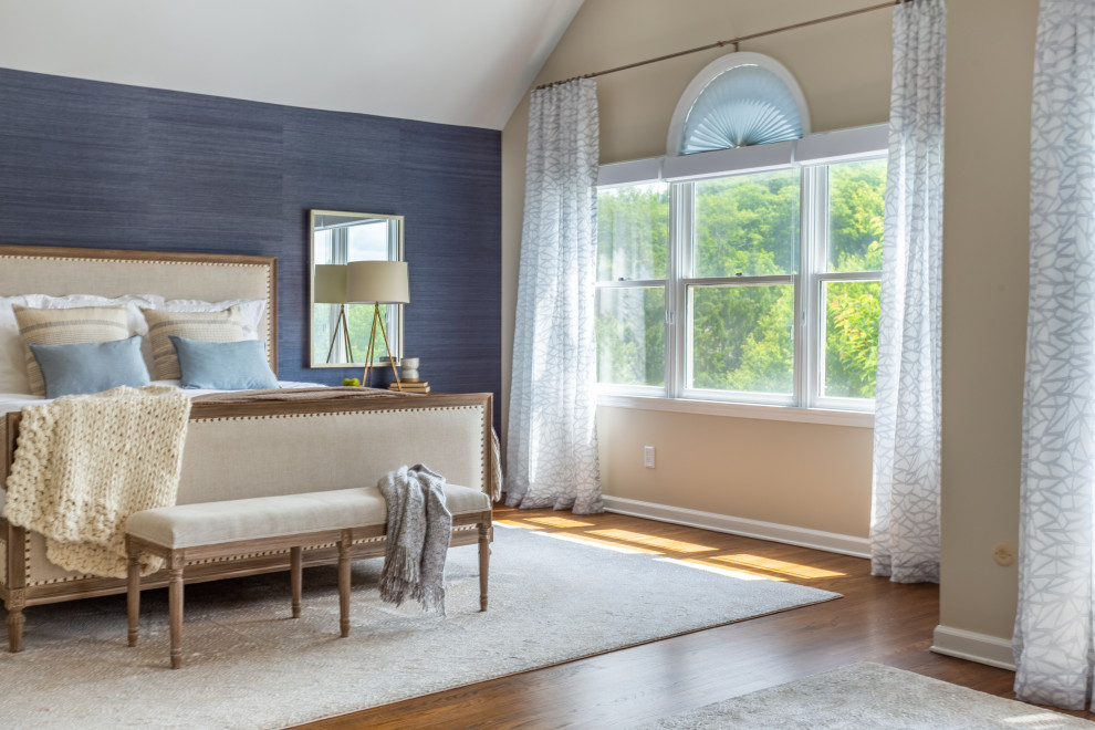 This is an example of a large modern master bedroom in New York with blue walls, light hardwood floors, no fireplace, beige floor, vaulted and wallpaper.