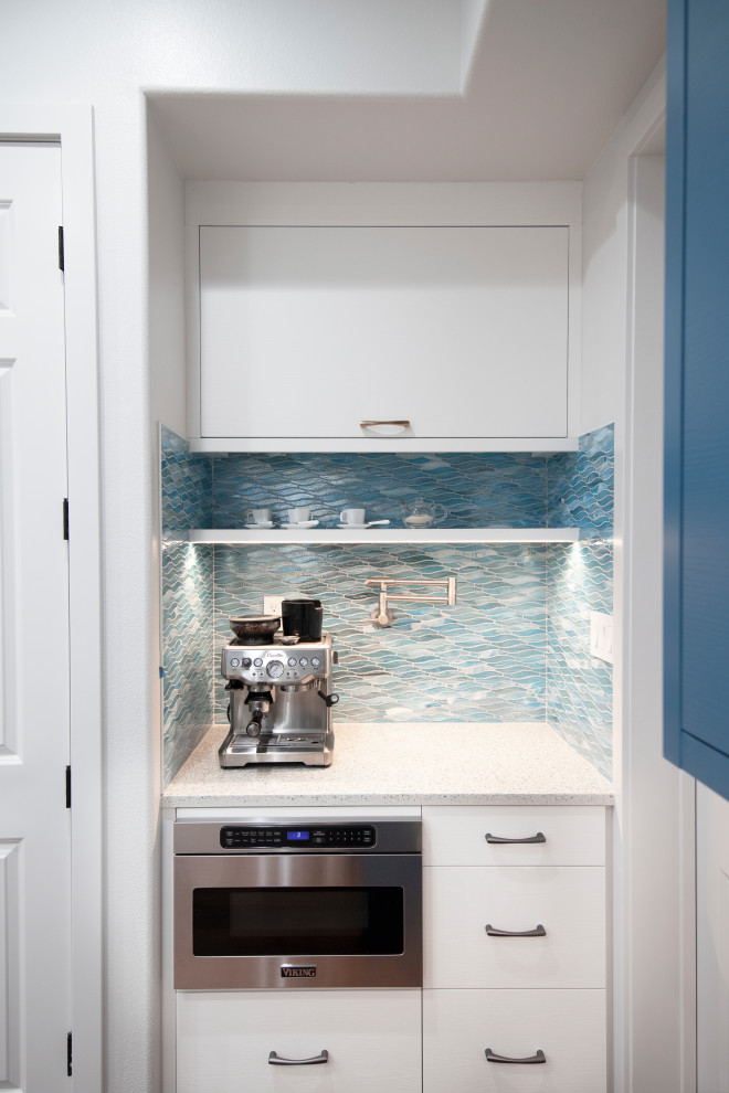 Idee per una grande cucina minimal con lavello da incasso, ante lisce, ante bianche, top in acciaio inossidabile, paraspruzzi blu, paraspruzzi con piastrelle a mosaico, elettrodomestici in acciaio inossidabile, pavimento in legno massello medio e top bianco