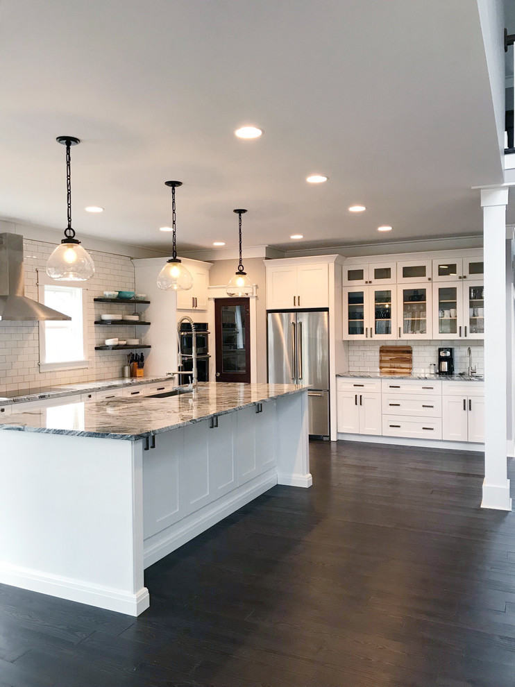 Design ideas for a country l-shaped kitchen in Other with white splashback, subway tile splashback, stainless steel appliances, dark hardwood floors, with island and brown floor.