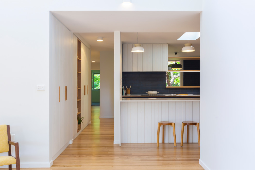 Design ideas for a mid-sized modern galley kitchen pantry in Canberra - Queanbeyan with a drop-in sink, blue cabinets, quartz benchtops, blue splashback, cement tile splashback, stainless steel appliances, medium hardwood floors and white benchtop.
