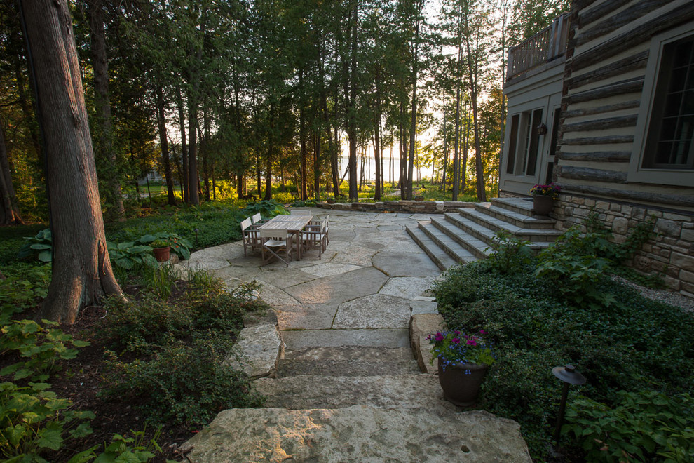 Photo of a large rustic partial sun side yard stone landscaping for summer.