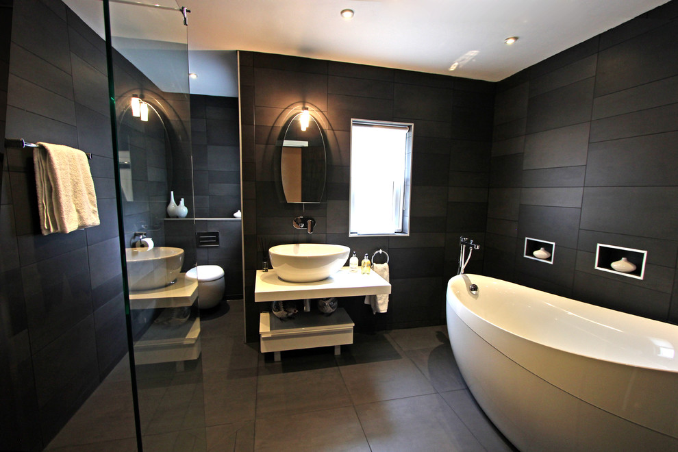 Large contemporary master bathroom in Manchester with white cabinets, black tile and black walls.