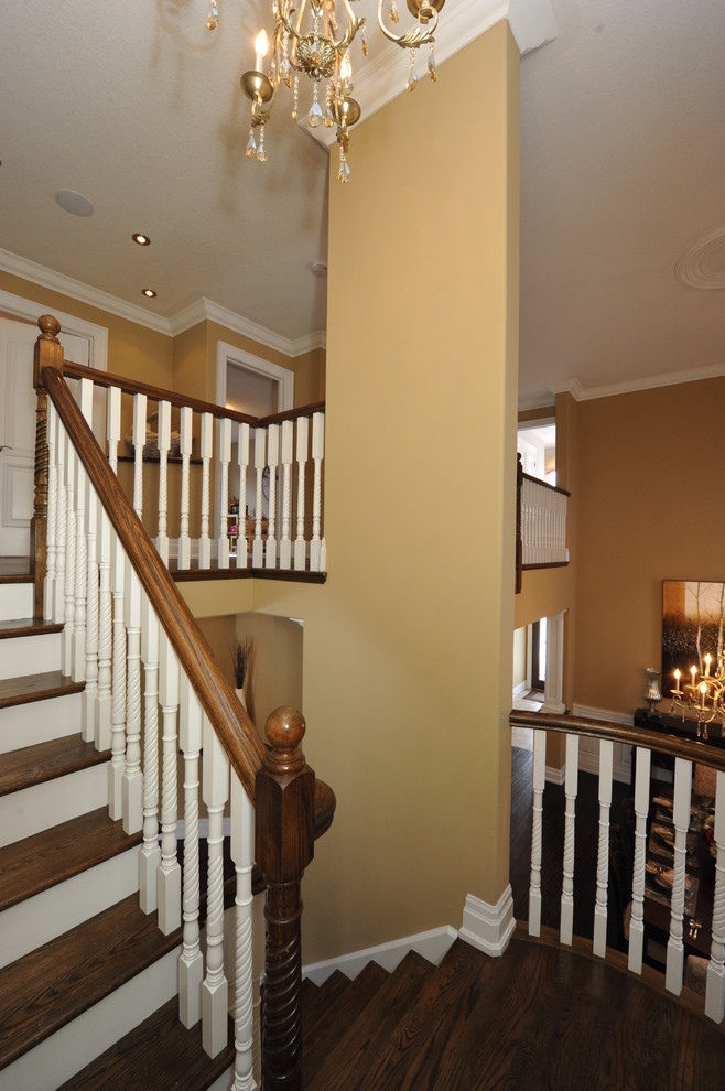 This is an example of a mid-sized traditional painted wood l-shaped staircase in Toronto with painted wood risers and wood railing.